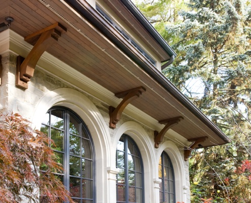 Traditional house with arched window, wood soffit and wood brackets.