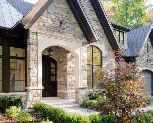 Stone home with stone column, gable and metal roof.