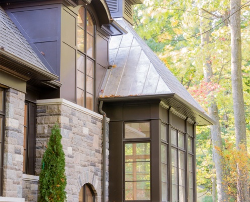 Traditional house with metal cladding, natural stone and floor to ceiling window.