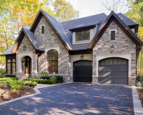 Traditional home with natural stone, gables and arch window.