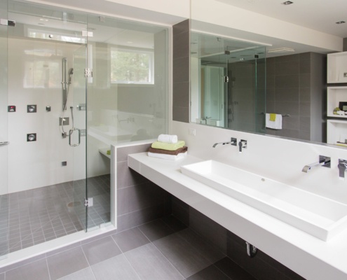 Bathroom with glass shower and tile floor.