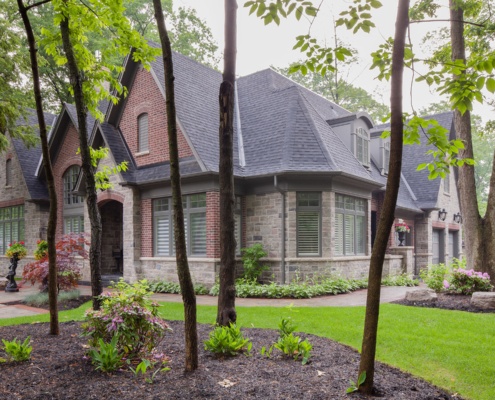 Traditional house with dark eaves, arched window and natural stone.