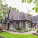 Custom home with gables, black frame windows and stone skirt.