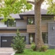 Mississauga house with black brick, landscape wall and sconce lighting.