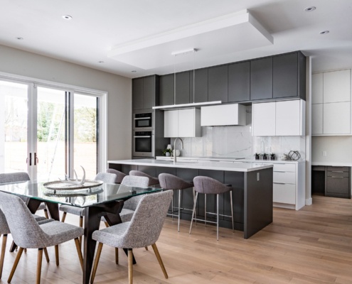 Open concept with modern pendant light, grey barstools and large windows.