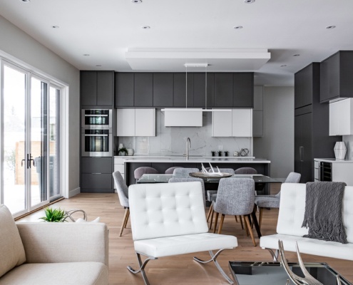 Modern living room with white furniture, hardwood floor and white baseboard.