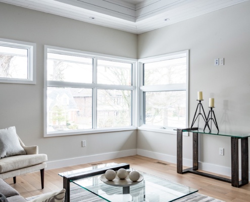 Mississauga living room with corner windows, white baseboard and hardwood floor.