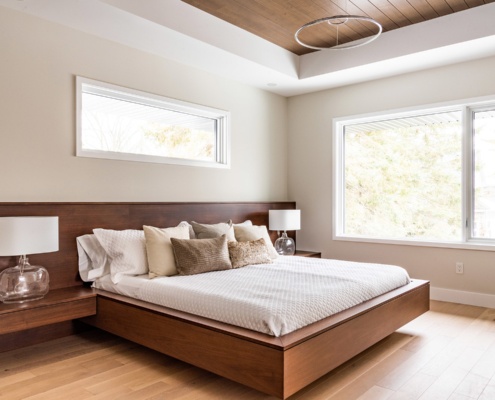 Wood master bedroom with white frame window and white baseboard.