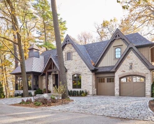 Stone house with gables, glass room and shingled roof.