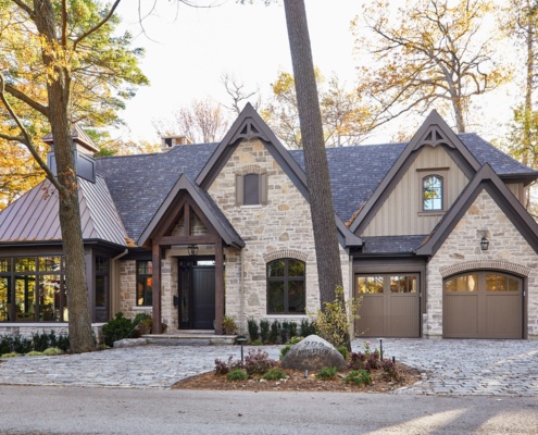 Custom home with wood siding, brown trim and wood accents.