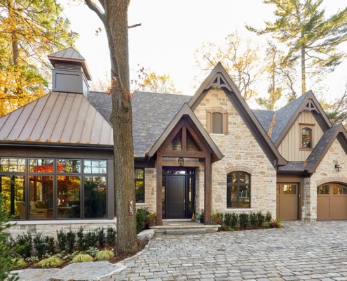 Rustic house with metal roof, shutters and black frame windows.