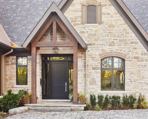 Traditional home with natural stone, brick and dark trim.