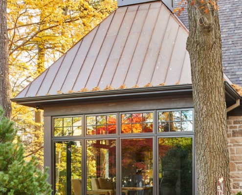 Custom home with floor to ceiling glass, metal roof and cupola.