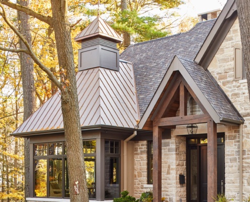 Traditional home with metal roof, wood pergola and natural stone.