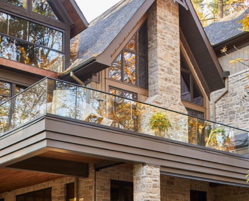 Custom home backyard with outdoor fireplace, stone column and wood ceiling.