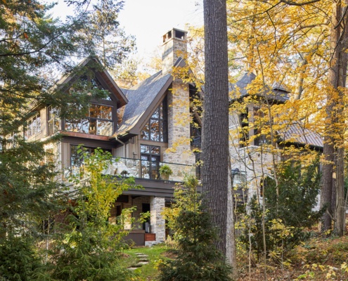 Traditional home with natural stone, gabled roof and dark trim.