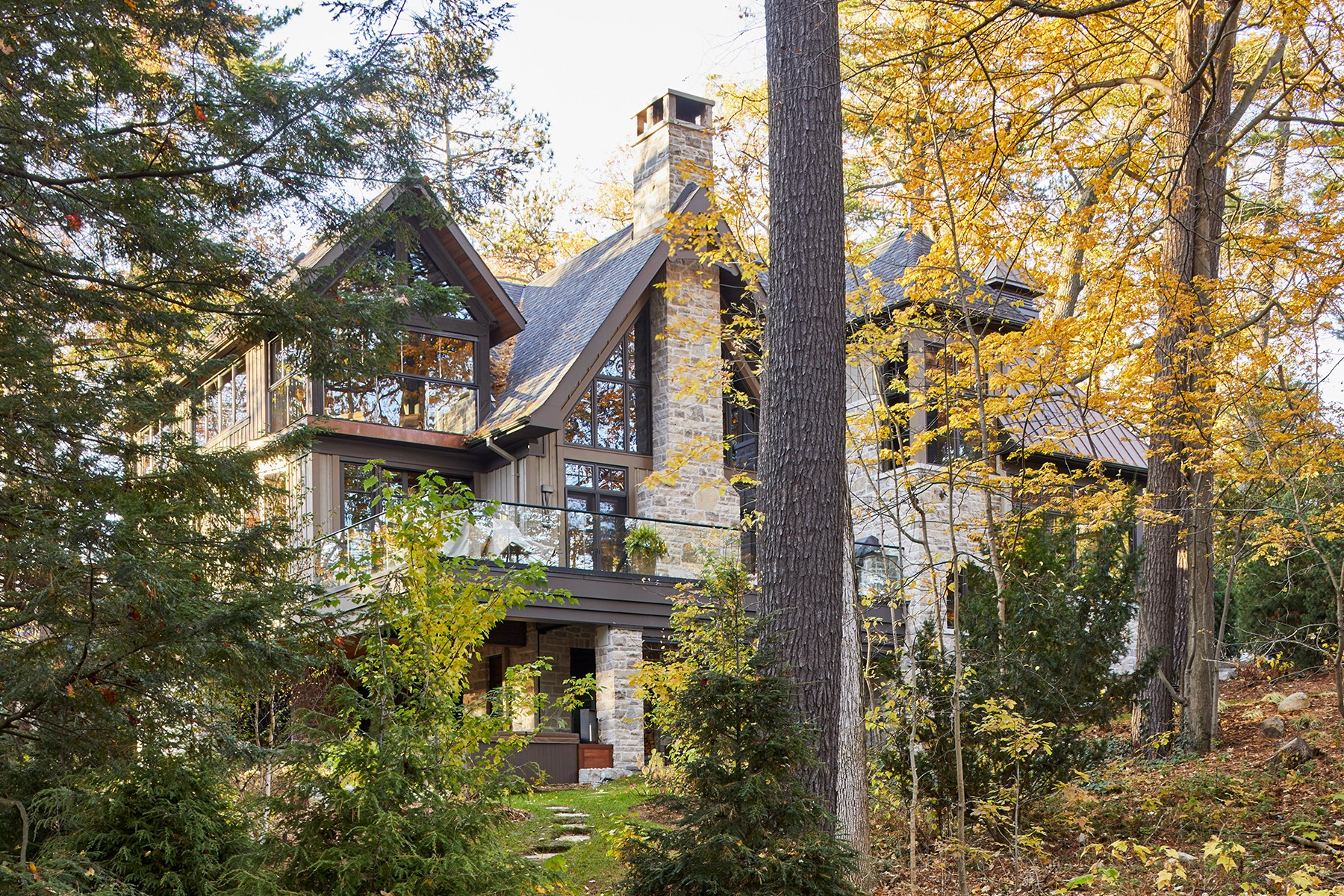 Traditional home with natural stone, gabled roof and dark trim.