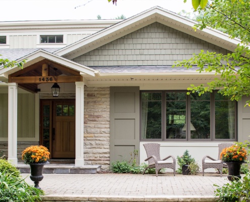 Mississauga home with green shutters, natural stone and wood beams.
