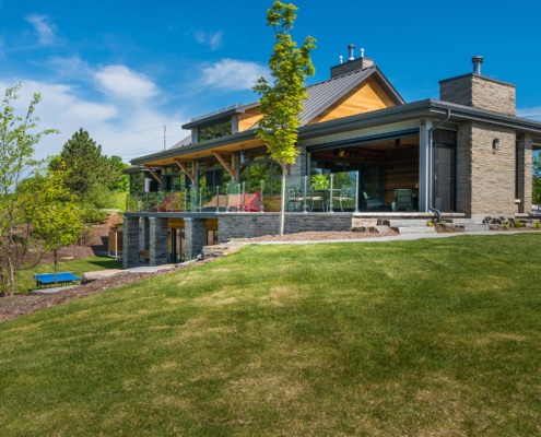Transitional cottage with steel beams, stone columns and wood soffit.