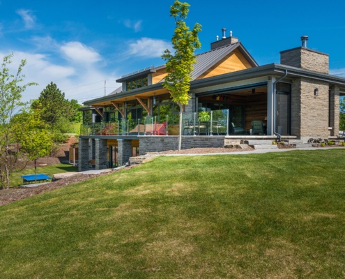 Transitional cottage with steel beams, stone columns and wood soffit.