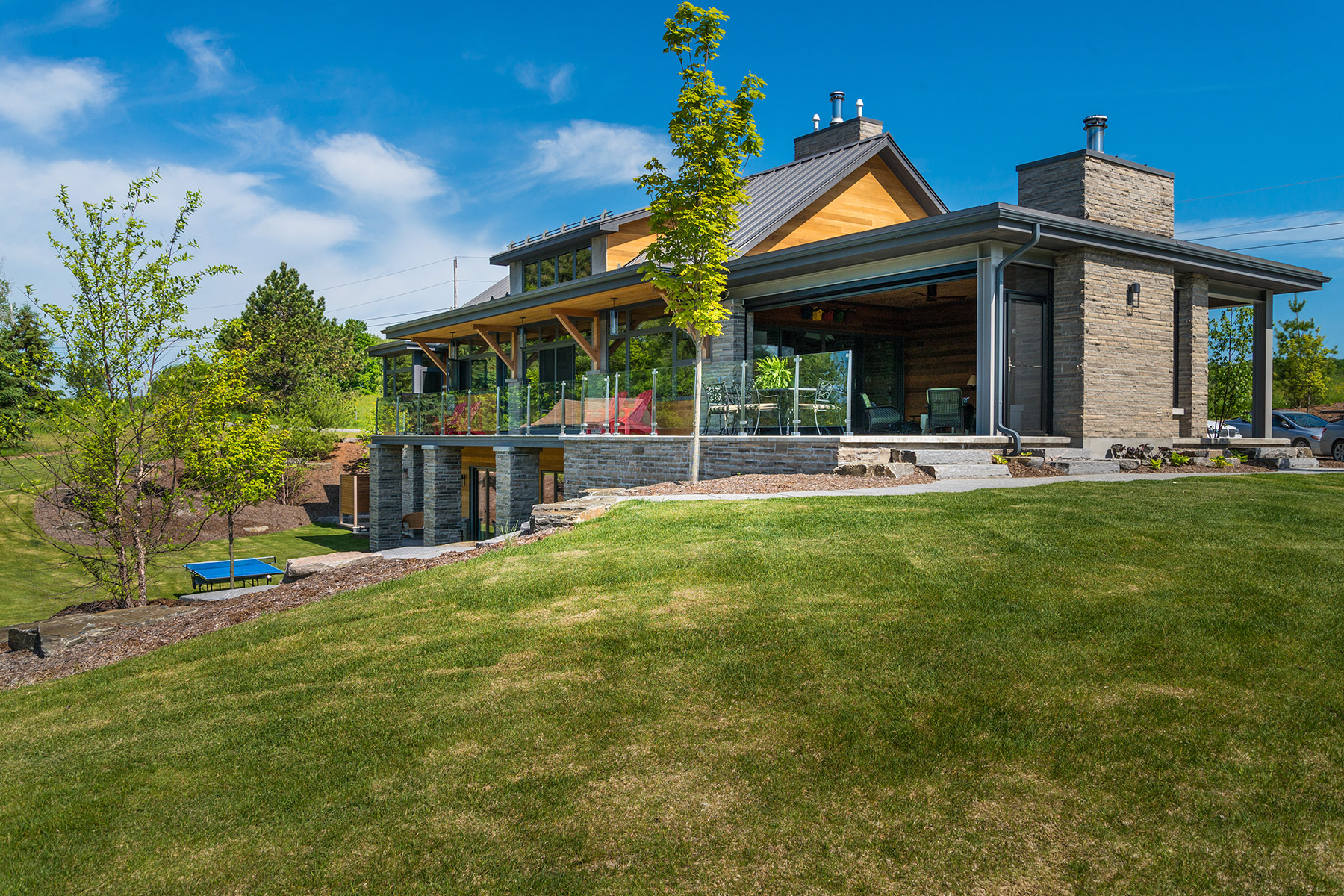 Transitional cottage with steel beams, stone columns and wood soffit.