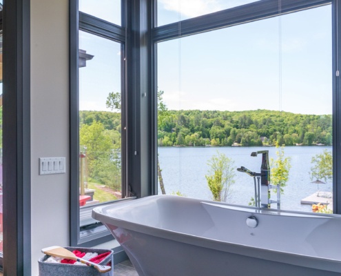 Cottage master bathroom with black frame windows, gray tile and black trim.