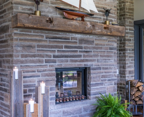 Traditional stone fireplace with wood mantle and wood floor.