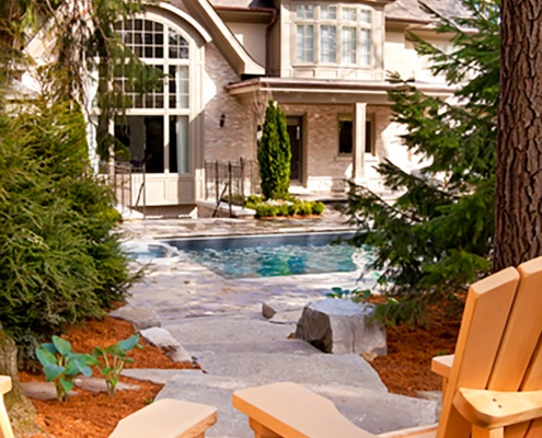 Traditional home with inground pool, gabled roof and light trim.