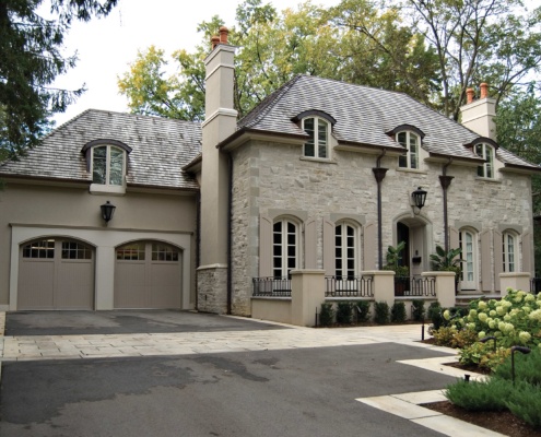 Traditional home with stucco, beige garage door and covered entry.