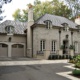 Traditional home with stucco, beige garage door and covered entry.