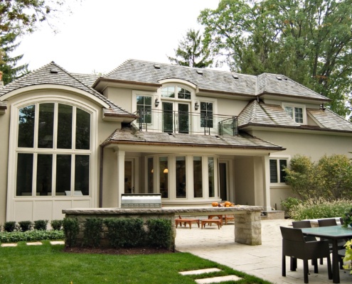 Mississauga house with stucco columns, wood shingles and outdoor barbeque.