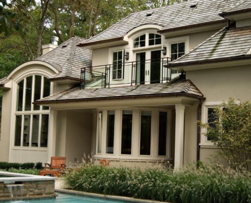 Traditional home with stucco siding, white frame windows and balcony.