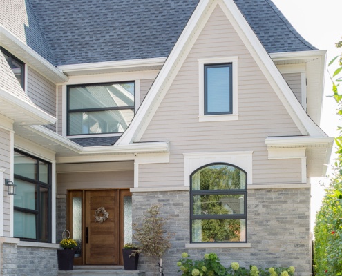 Mississauga home with large gable, wood siding and stone driveway.