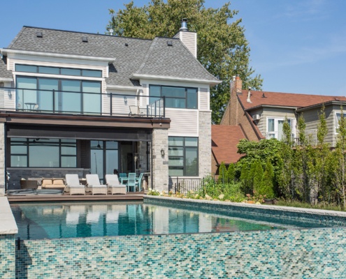 Mississauga custom home with natural stone, backyard pool and shingled roof.