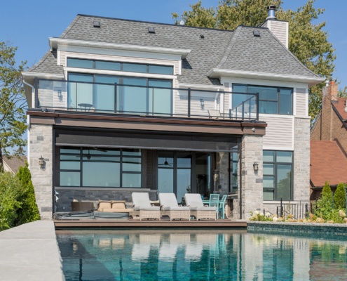 Transitional house with second floor balcony, covered deck and natural stone.