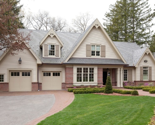 Traditional home design with two car garage, shutters and brick skirt.