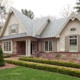 Home design with covered entry, exterior brick and oval window.