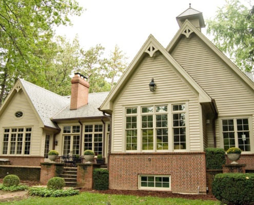 Rear home elevation with red brick, wood siding and cupola.