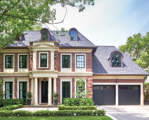 Traditional house with arched windows, brick and black frame windows.