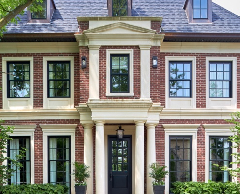 Georgian house with black front door, columns and red brick.