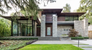 Mississauga house with wood trim, metal cladding and concrete planter.