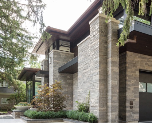 Large custom house with natural stone, metal cladding and stone planters.