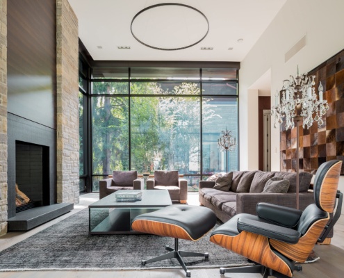 Sitting area with stone columns, wood trim and black frame window.