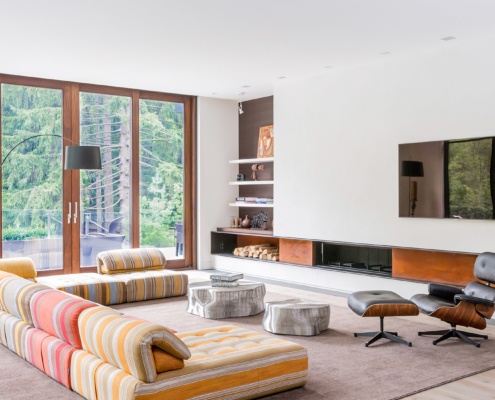 Family room with floor to ceiling windows, wood trim and hardwood floor.