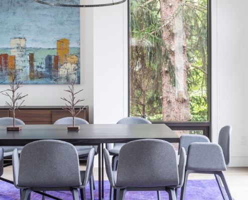 Modern dining room with floor to ceiling window, white baseboard and purple carpet.