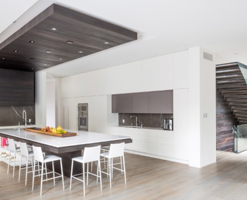 Modern kitchen with white cabinets, gray cabinets and wood accents.