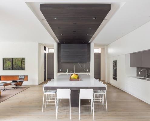 Contemporary kitchen with white island, marble backsplash and white countertops.