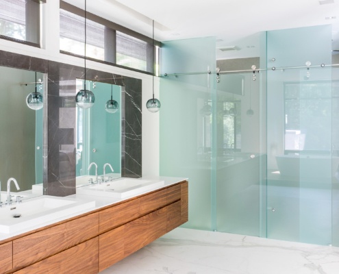 Ensuite bathroom with double sink, floating vanity and pendant lights.