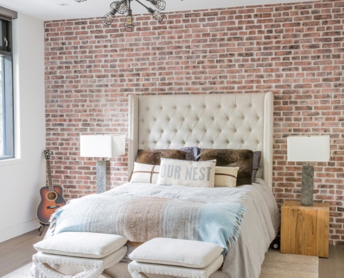 Guest bathroom with brick wall, white baseboard and wood floor.