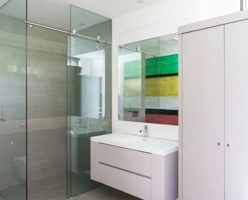 Modern bathroom with floating vanity, tile floor and glass shower.